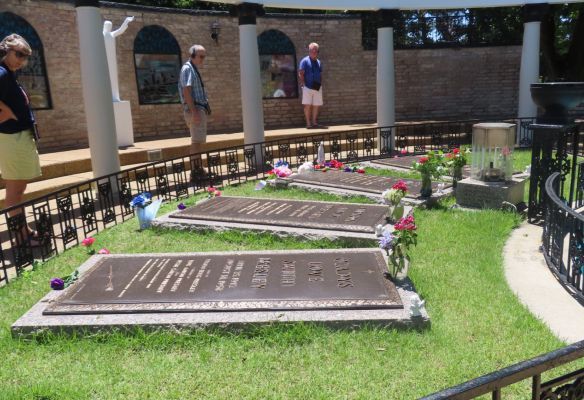 a group of people are standing in front of a graveyard - Meditation Garden at Graceland