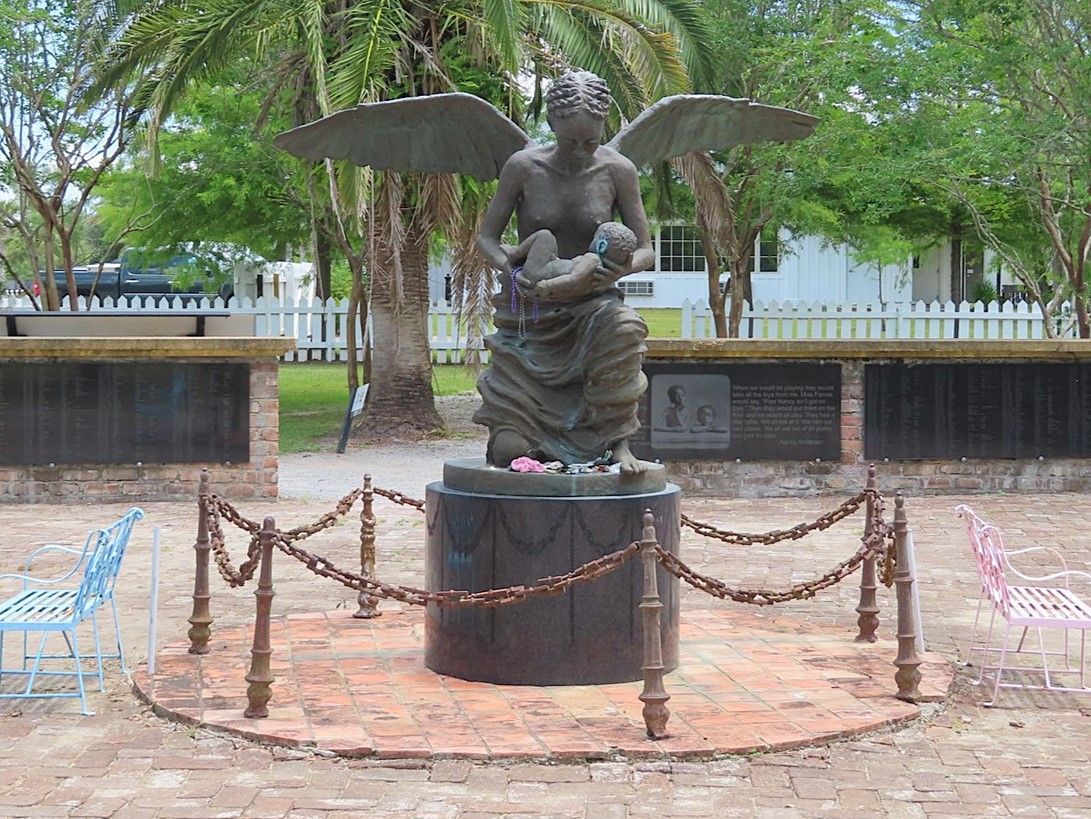 A statue of a woman with wings holding a baby