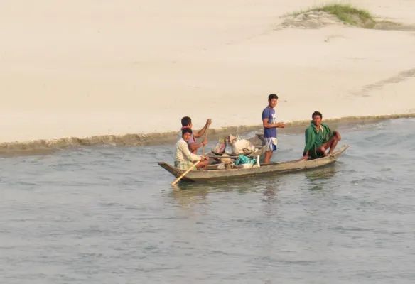 A group of people are fishing in a small boat on the Brahmaputra river.