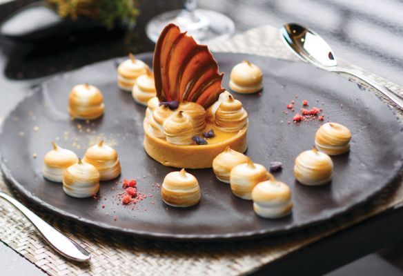 A dessert on a black plate with a spoon on SIlver Spirit