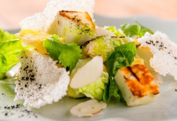 A close up of a salad on a plate on a table.