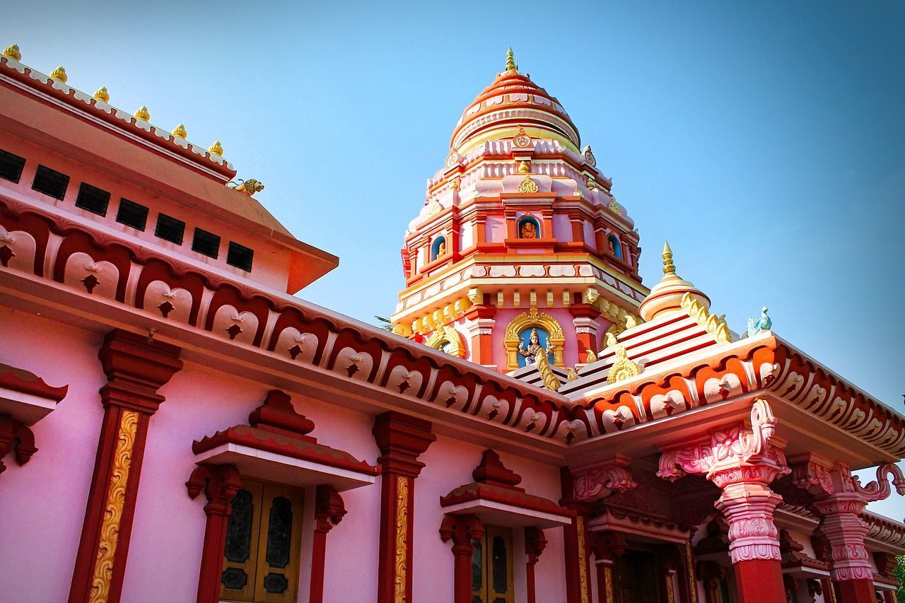 A pink and red temple with a blue sky in the background