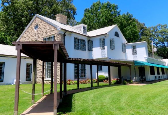 The Mansion at Graceland, a large white house with a walkway leading to it .