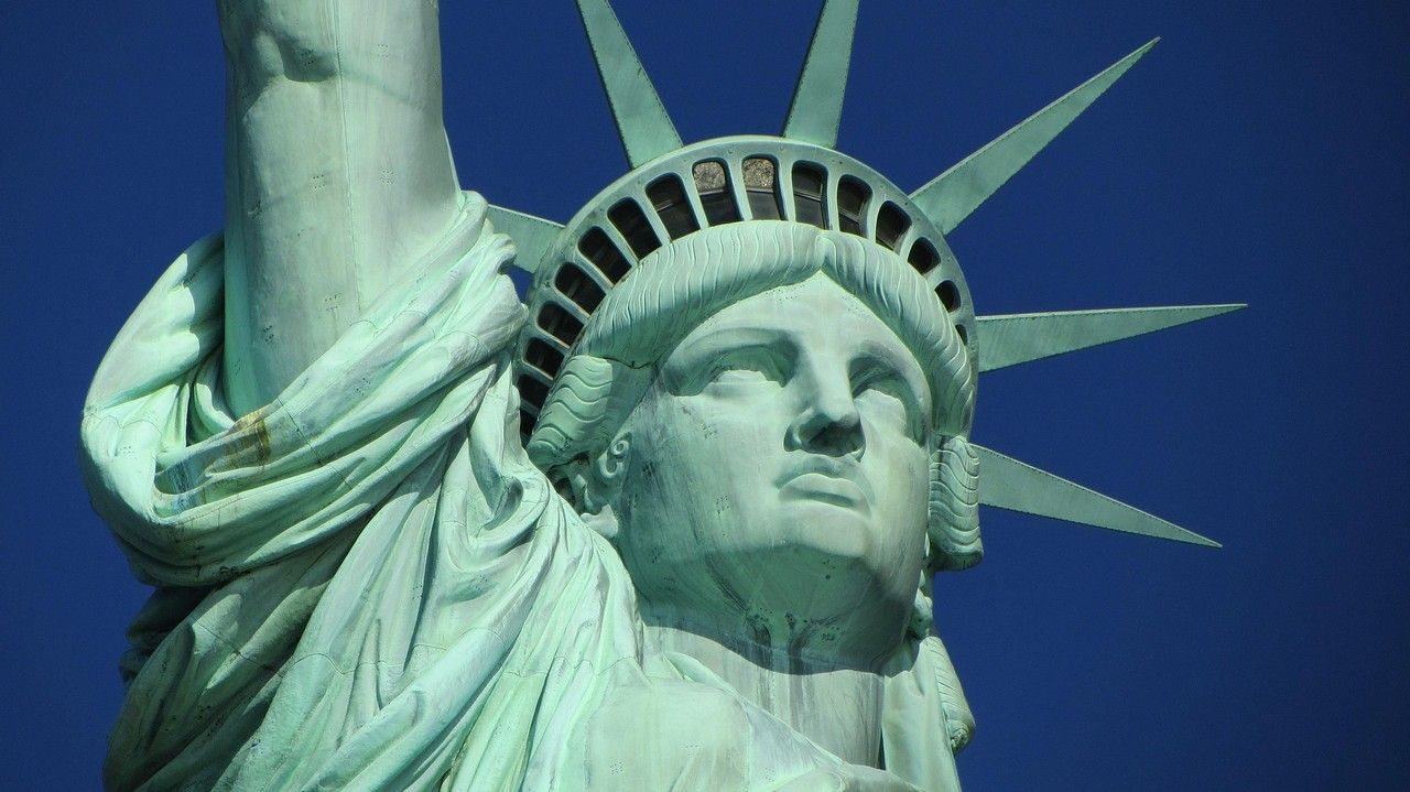 A close up of the statue of liberty against a blue sky.