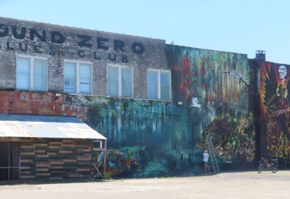 a man is painting a mural on the side of a building  at Ground Zero Blues Club Clarksdale Mississippi