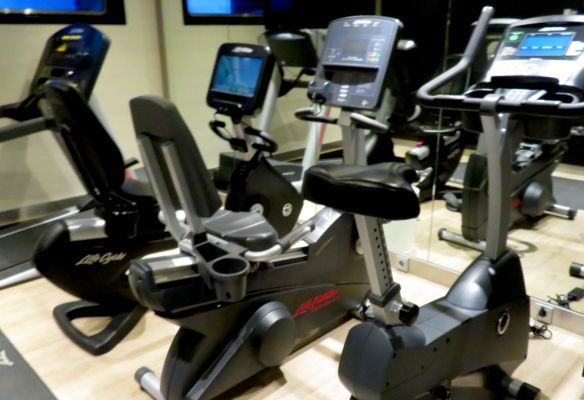 a row of exercise bikes are lined up in a gym onboard Avalon Envision