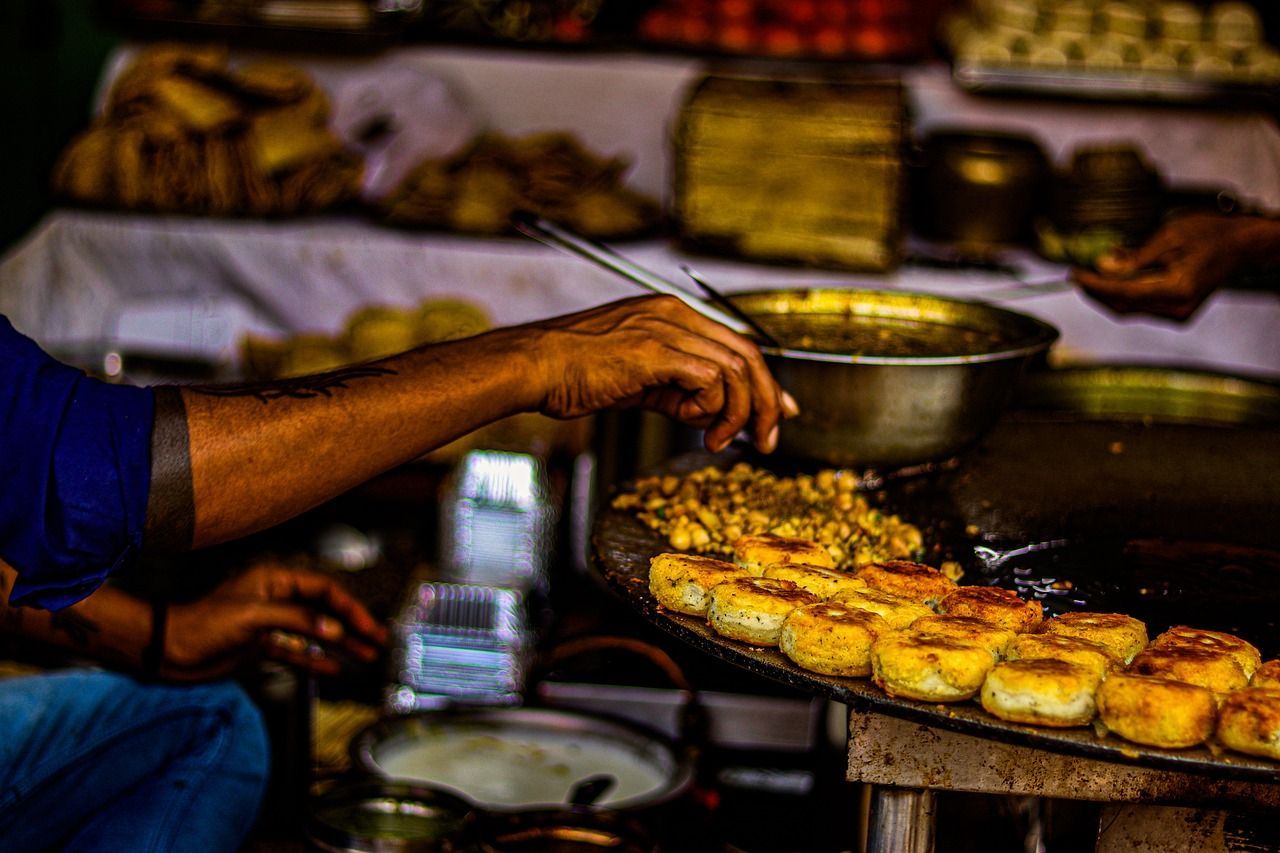 A person is cooking food in a pan on a stove in india