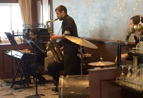 a man is playing a saxophone in a band at the Jazz Brunch on Azamara Quest