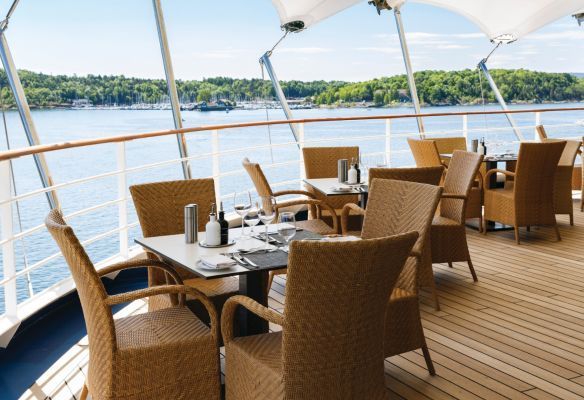 Tables and chairs on a deck overlooking a body of water