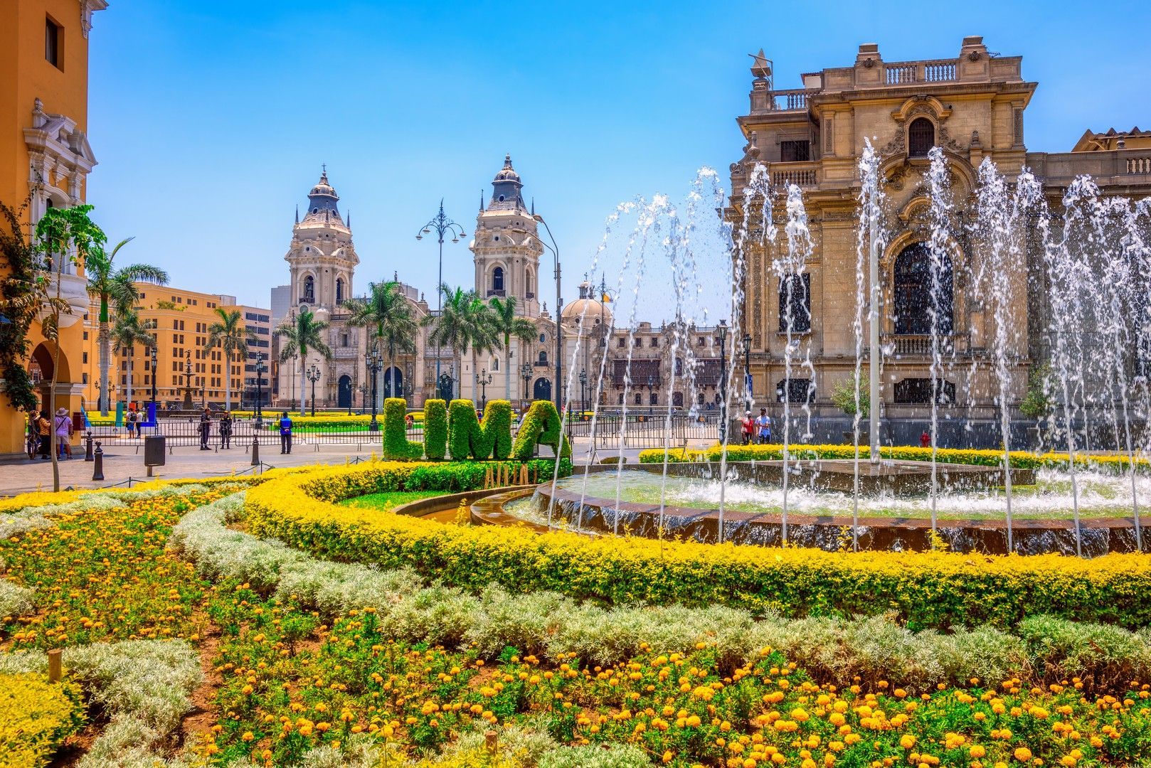 There is a fountain in the middle of a garden in lima.