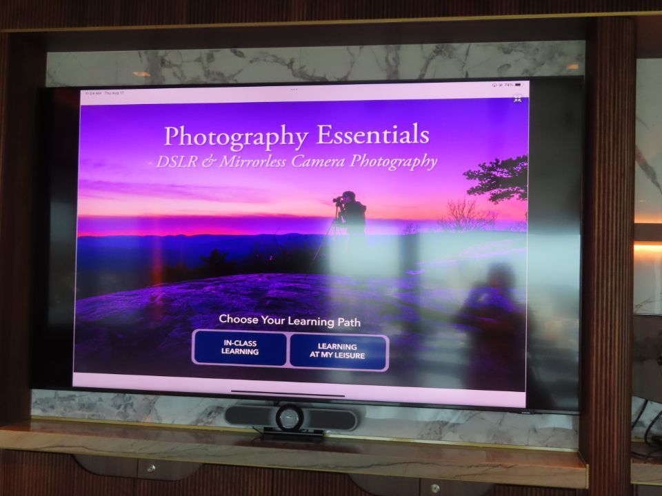 A television with a screen that says photography essentials on it.