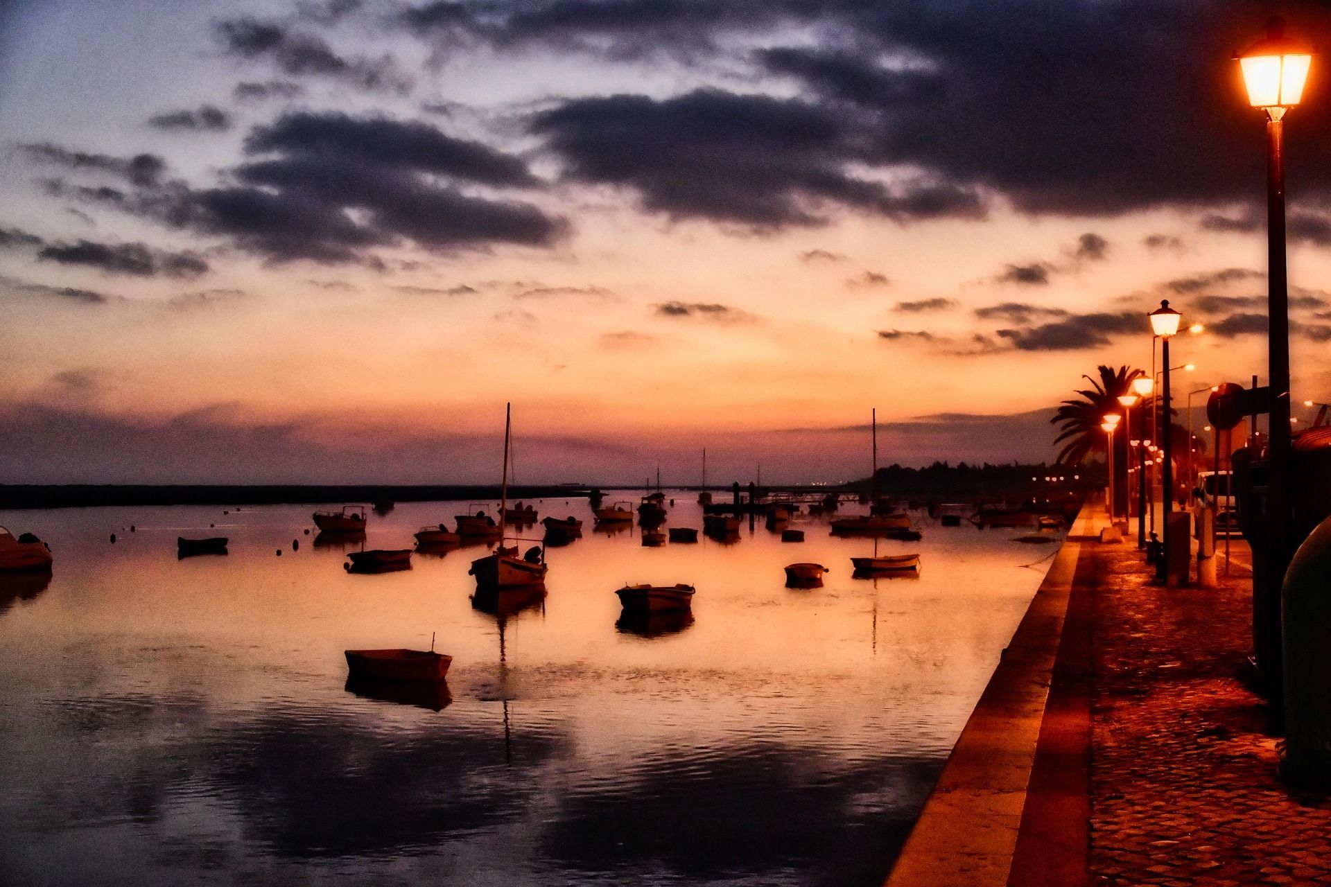 A sunset over a body of water with boats in it