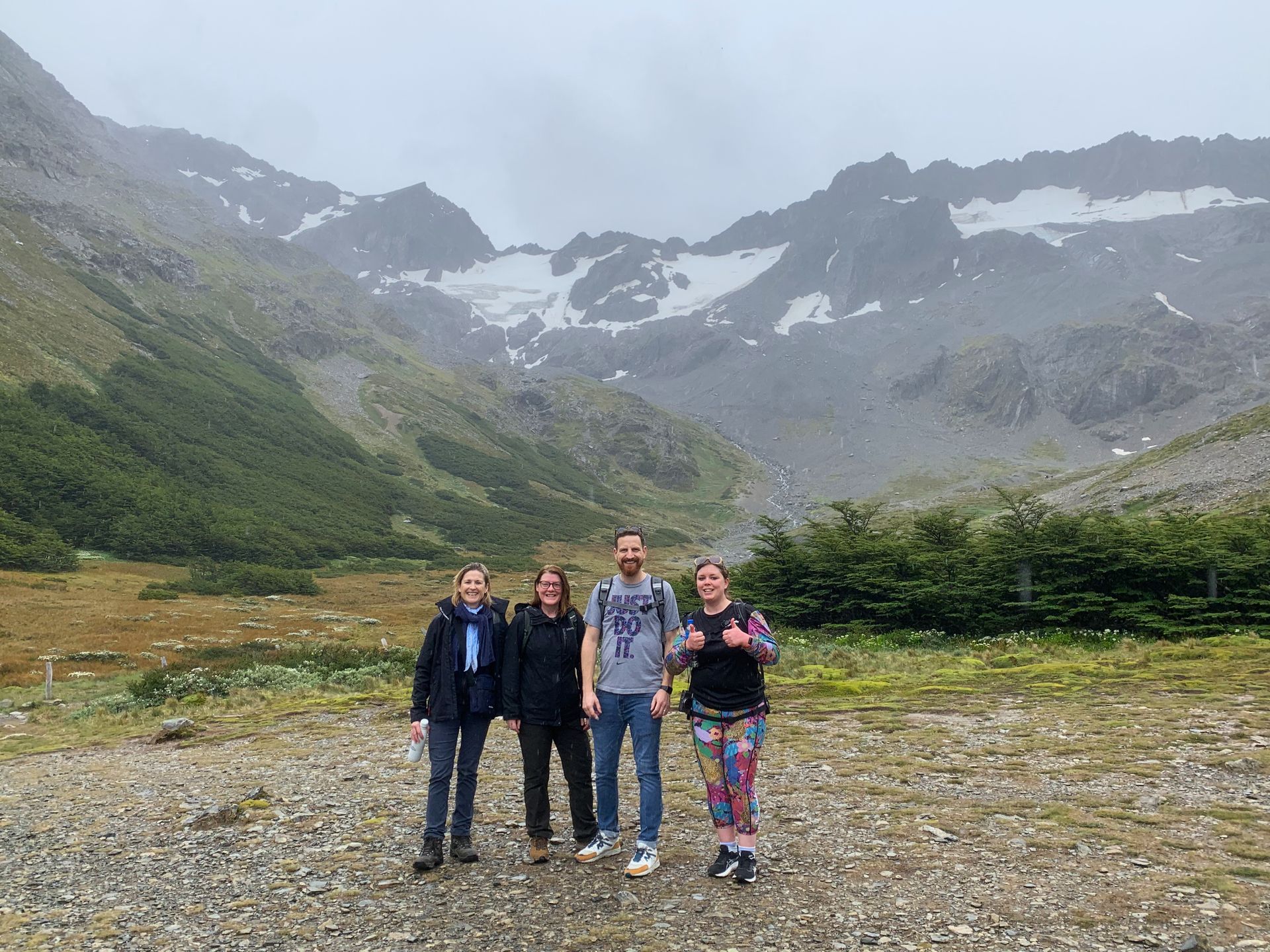 A group of people are standing in front of a mountain in Ushuaia