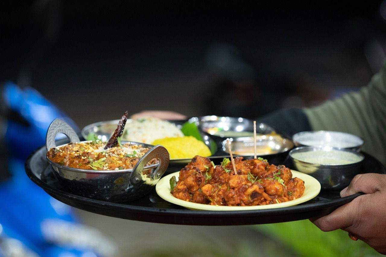 A person is holding a tray of food in their hands in india