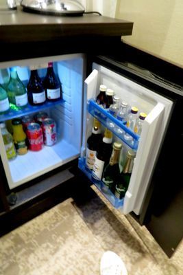 a small refrigerator mini bar filled with bottles and cans of soda onboard Avalon Envision