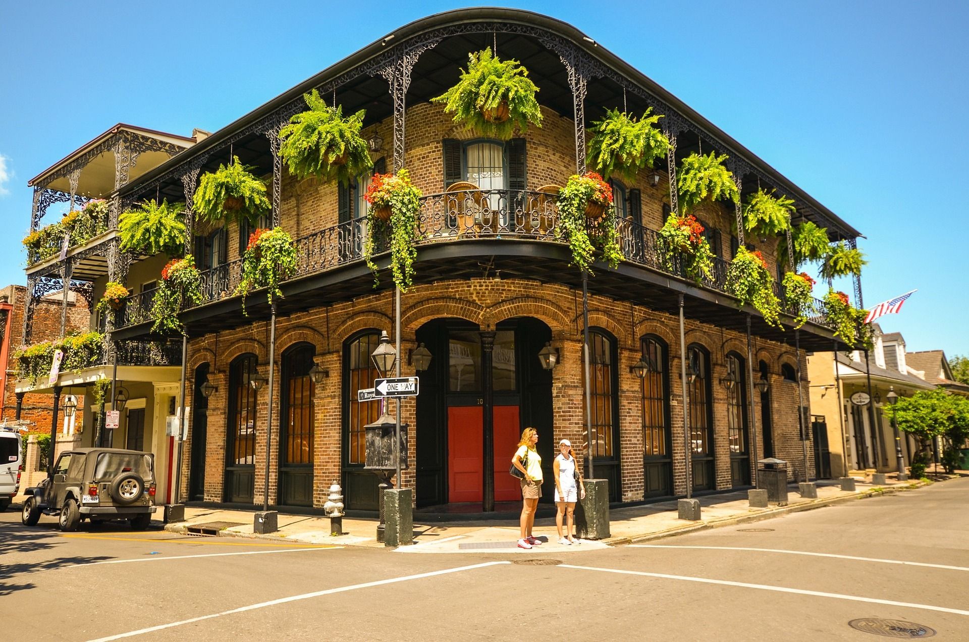 Two women are standing in front of a building with a red door in New Orleans