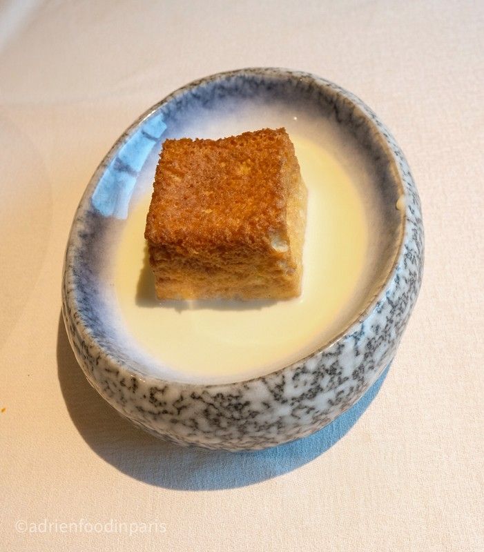 A blue and white bowl with a piece of nikkei food in it