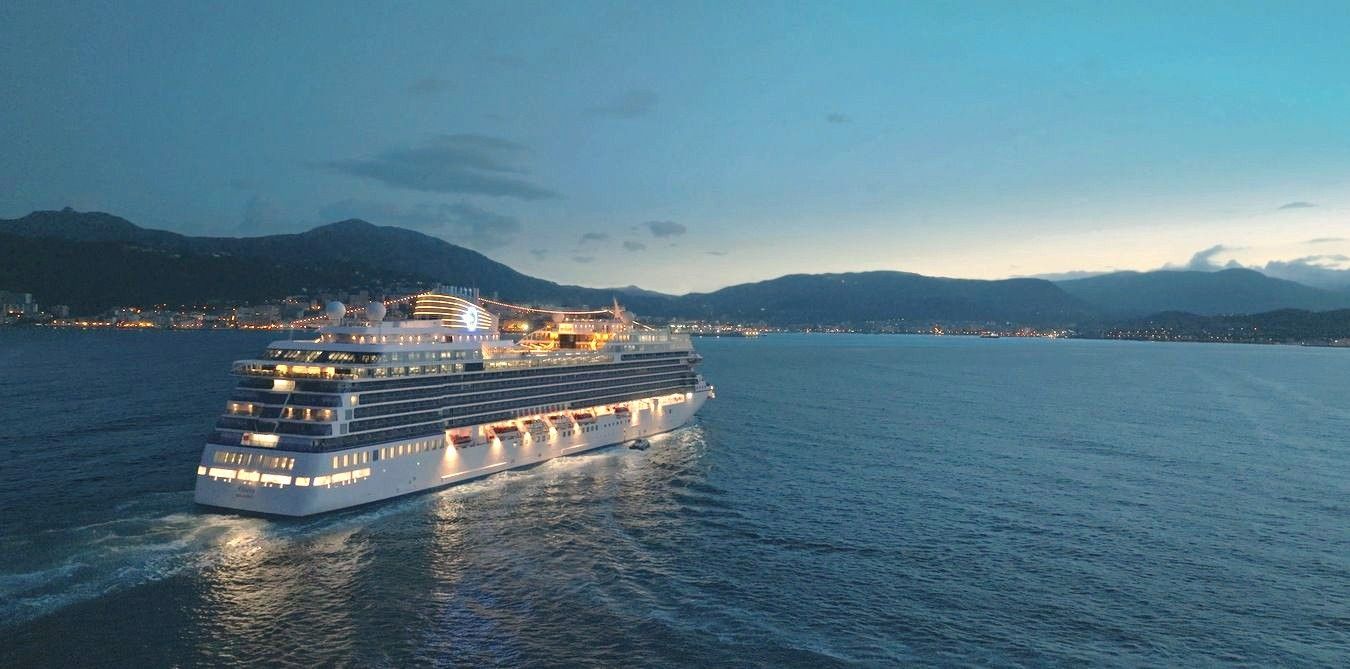 A large cruise ship called Allura is floating on top of a body of water.