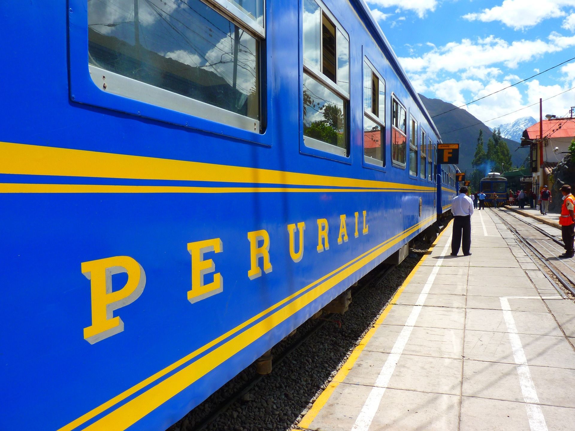 A blue and yellow train with the word perurail on the side