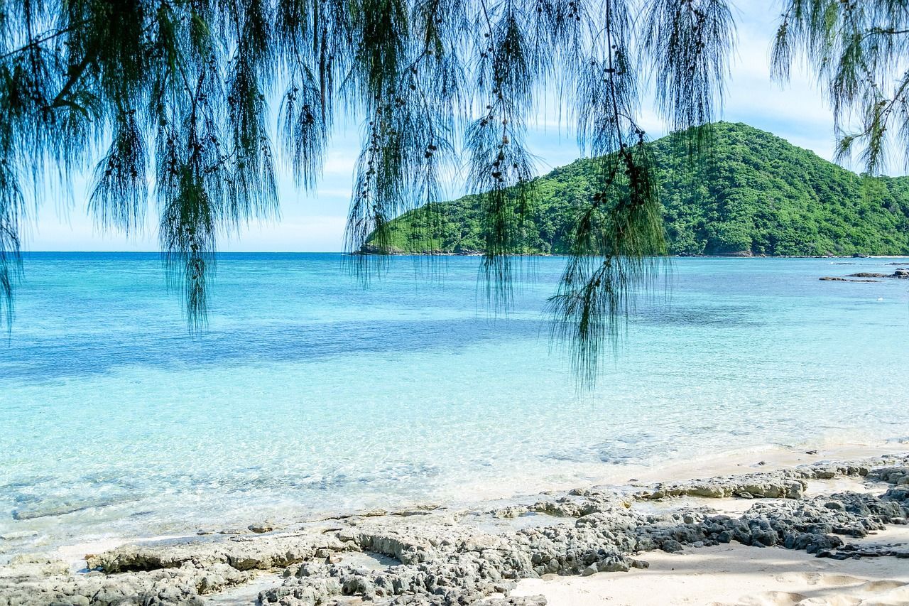 A beach with a mountain in the background and a beach on the Princess Cruises 2027 World Cruise 