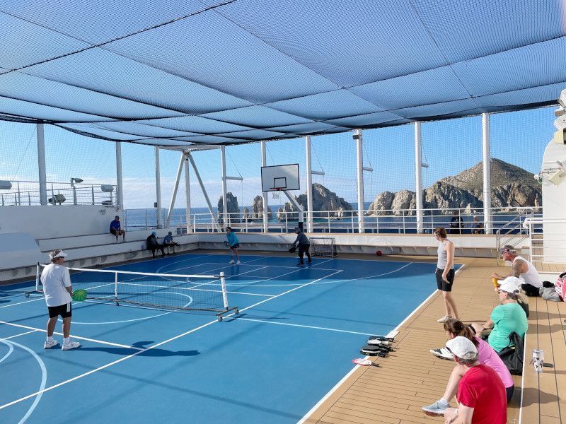 a group of people are playing pickleball on a blue court