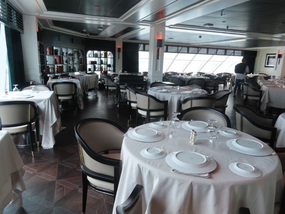 A large dining room with tables and chairs set for dinner