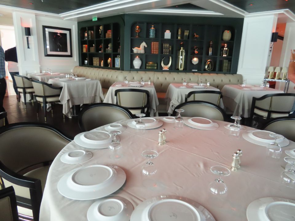 A restaurant filled with tables and chairs with plates and glasses on them