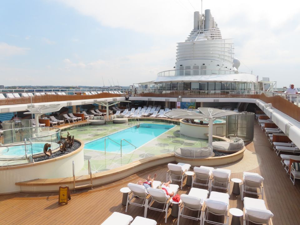 A large cruise ship has a large swimming pool on the deck