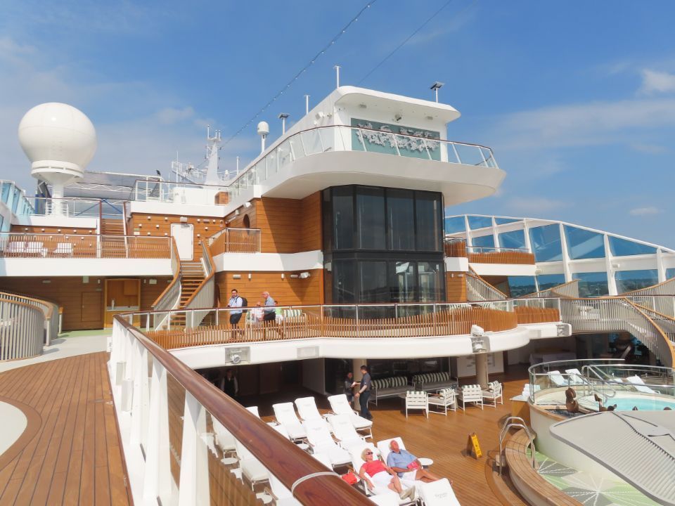 People are sitting on a deck of a cruise ship