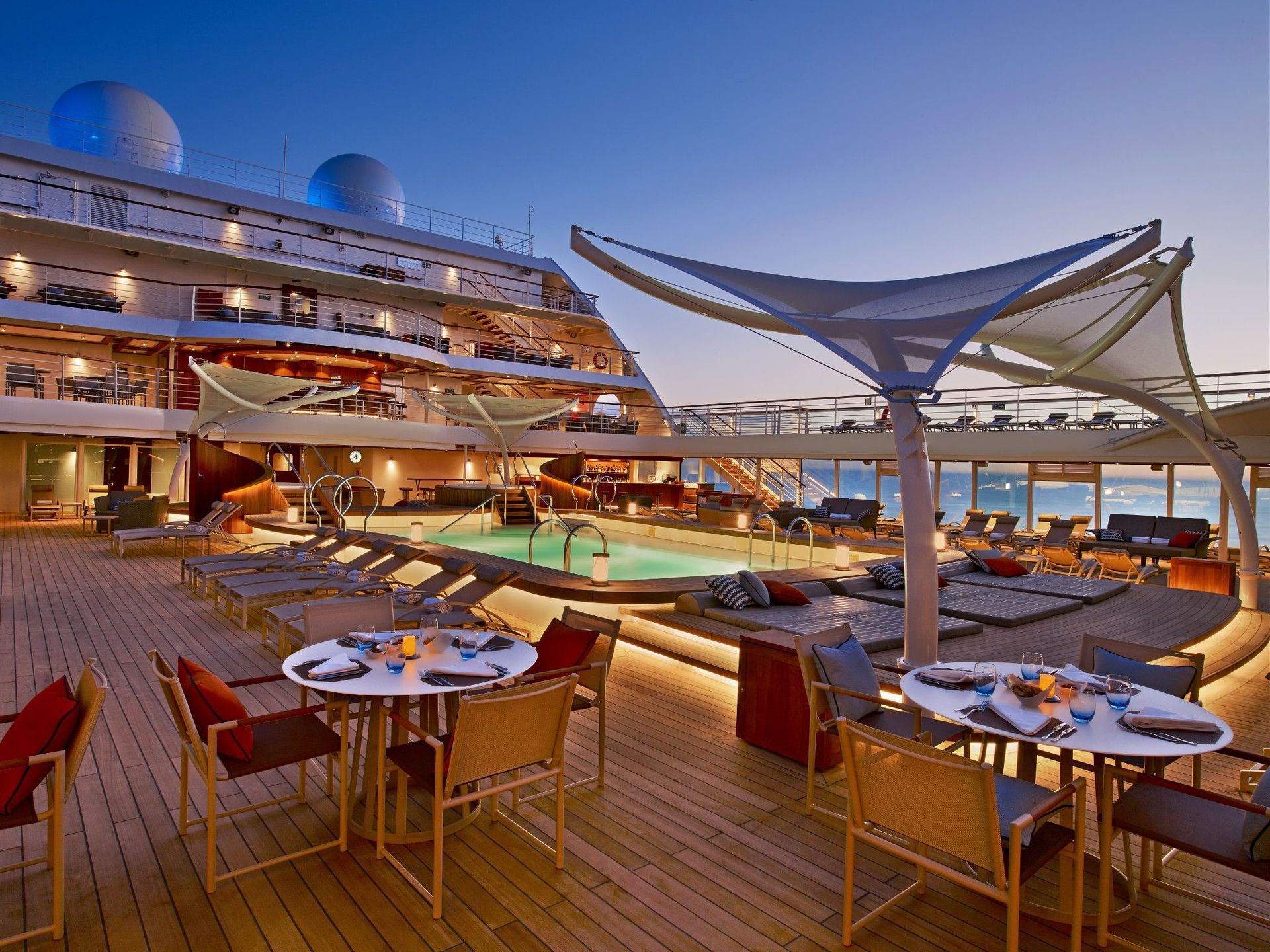 a cruise ship with tables and chairs on the deck, Pool Deck on Seabourn Encore