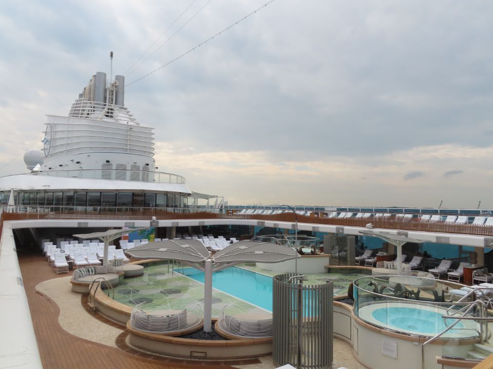 A large cruise ship with a large swimming pool on the deck.