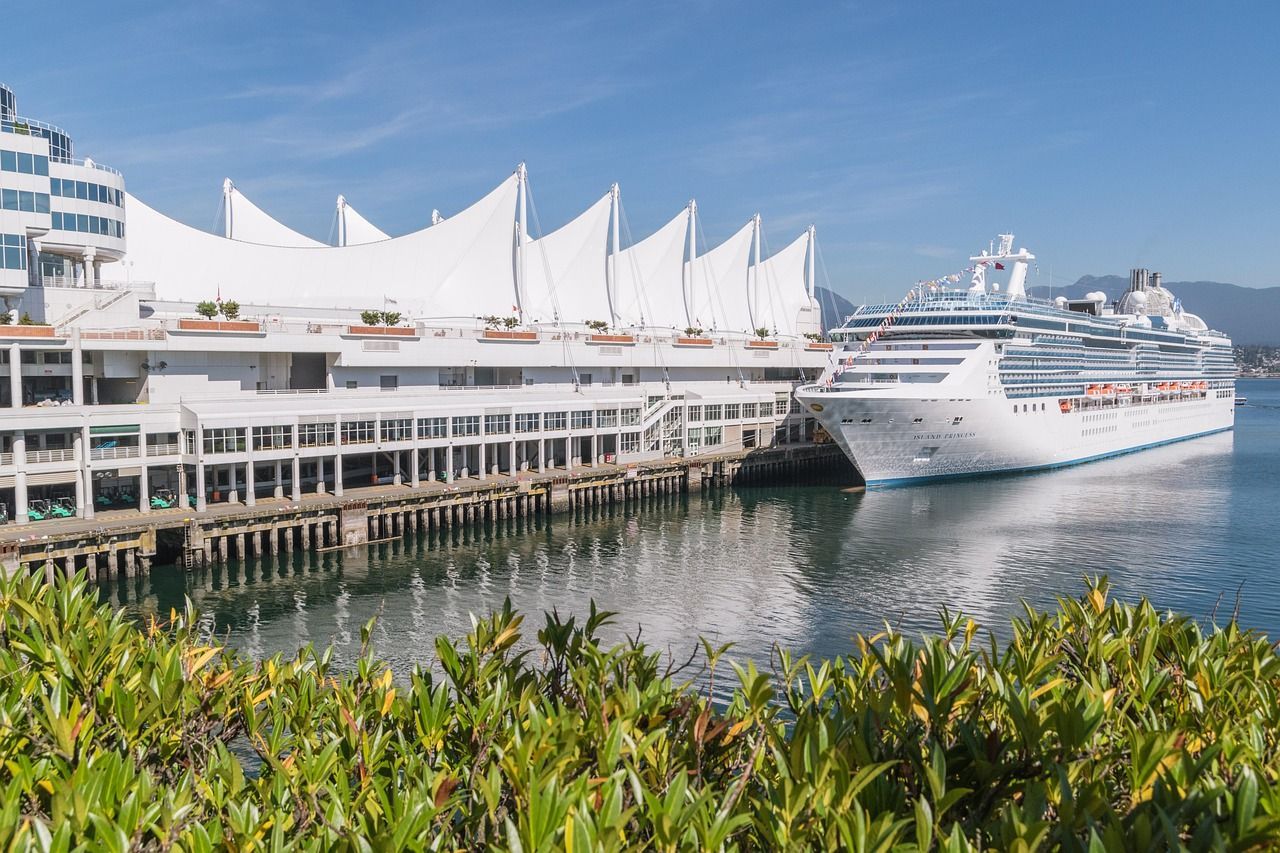 A cruise ship is docked in a harbor next to a building in Vancouver