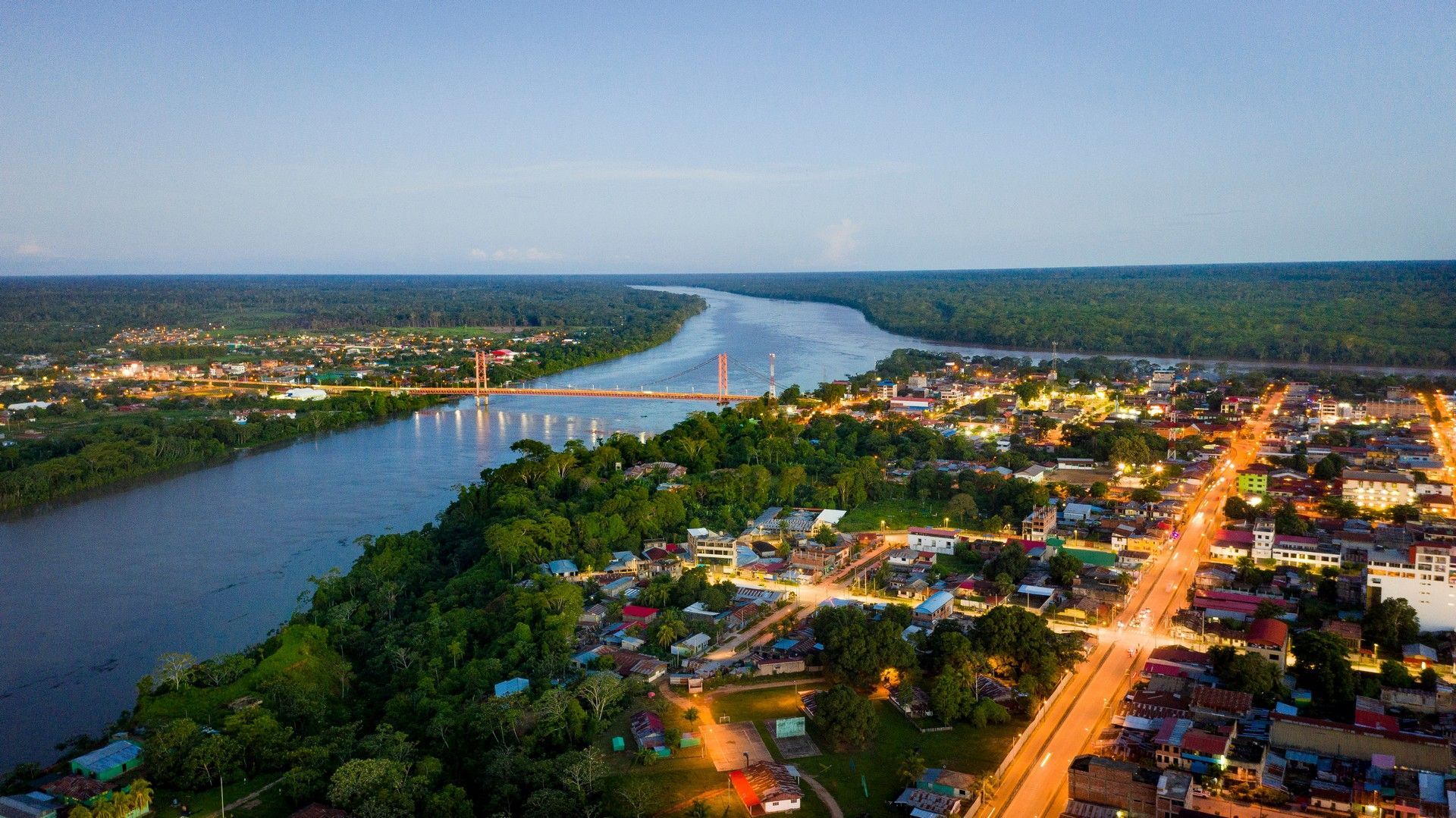 An aerial view of Puerto Maldonado surrounded by trees and a river.