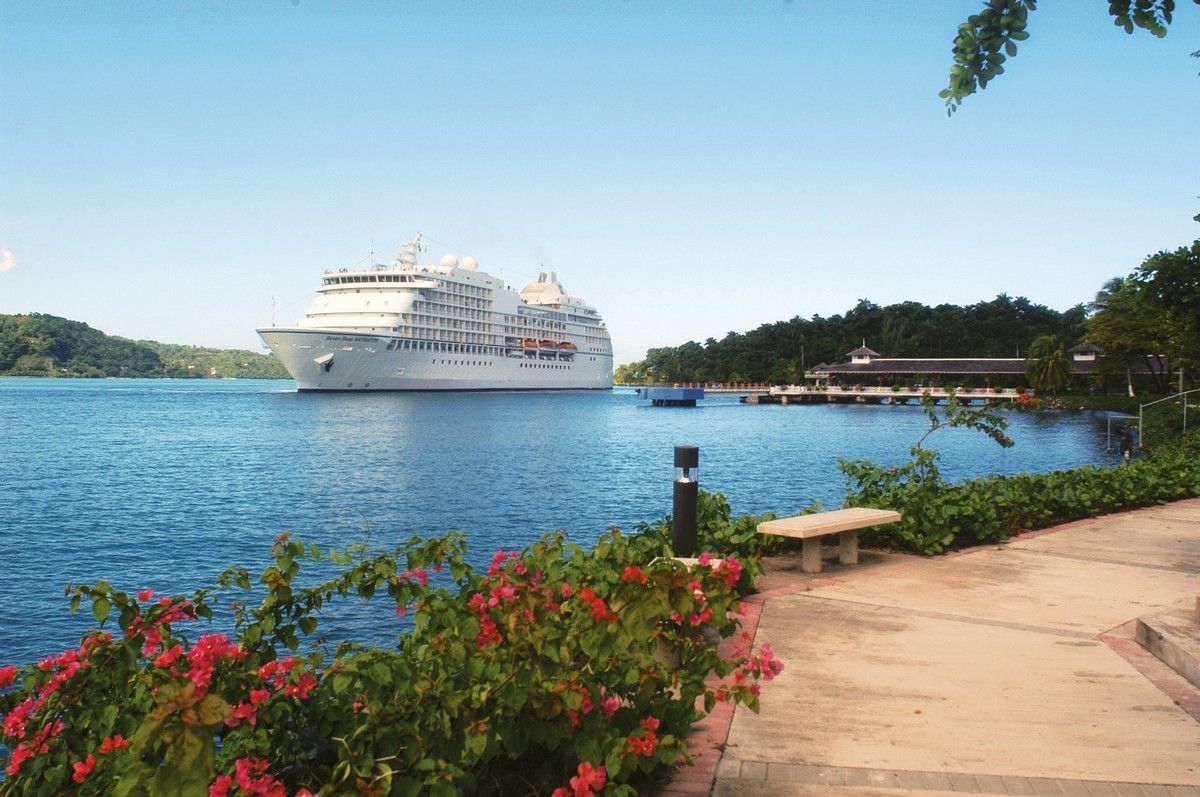 A large regent  cruise ship is docked in a body of water