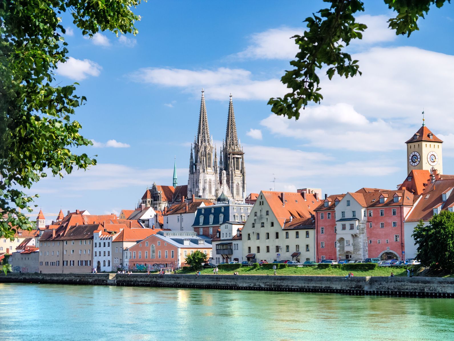 A city along a river with a cathedral in the background