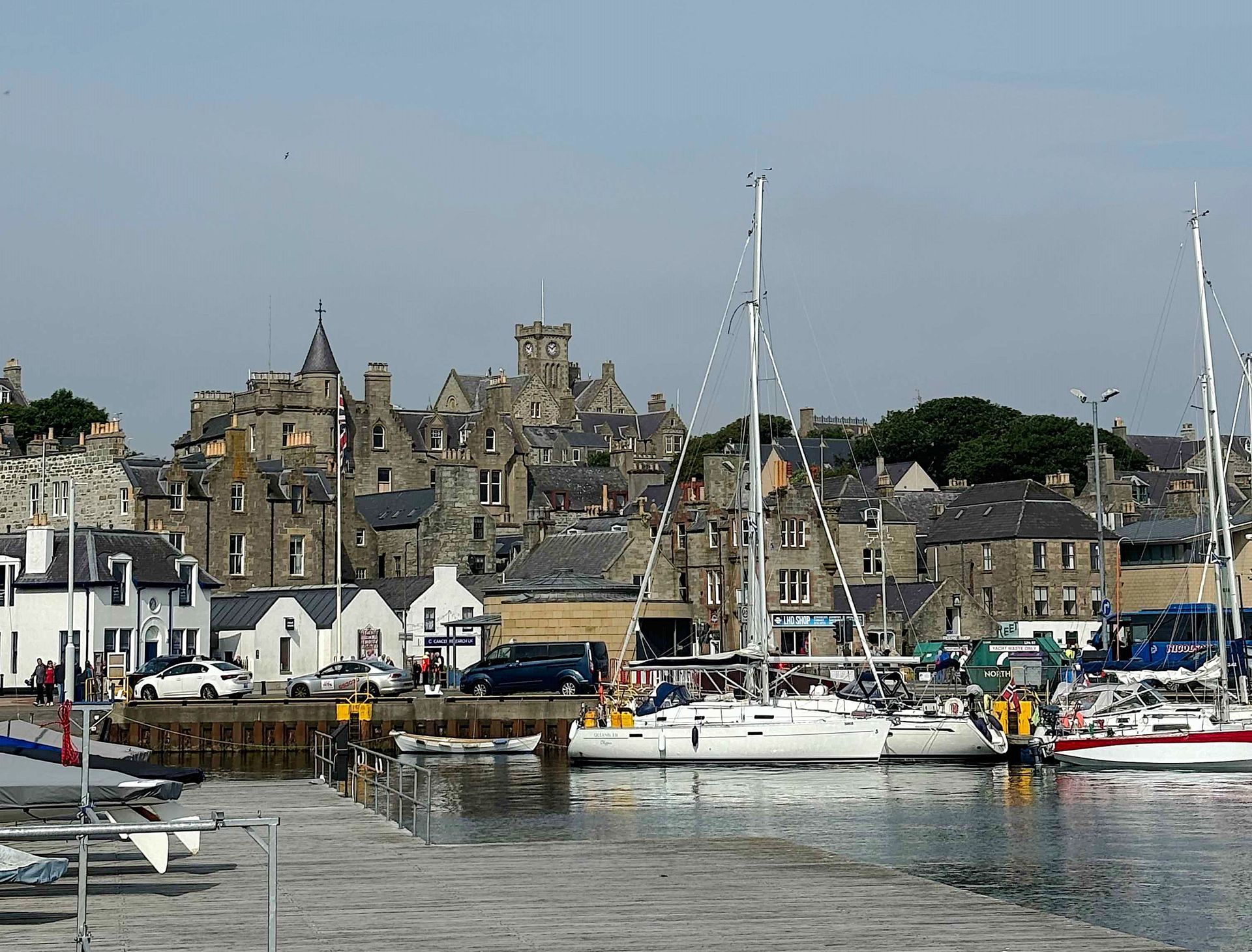 Boats are docked in a harbor with a city in the background