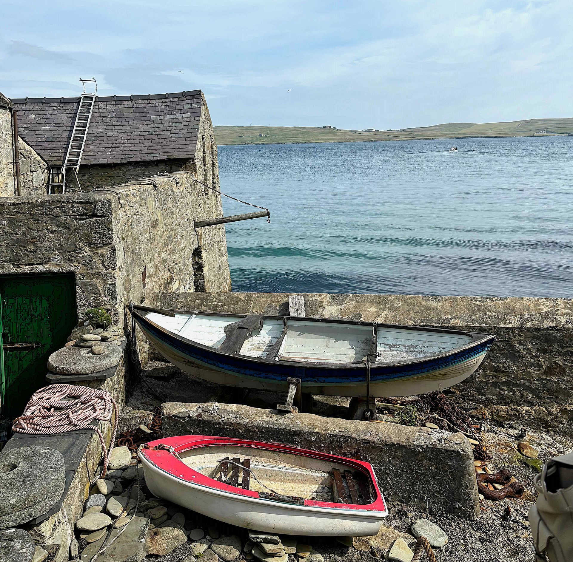 Two boats are sitting on the shore of a body of water.