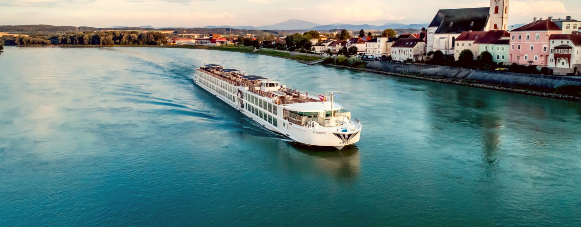An aerial view of a cruise ship sailing down a river.