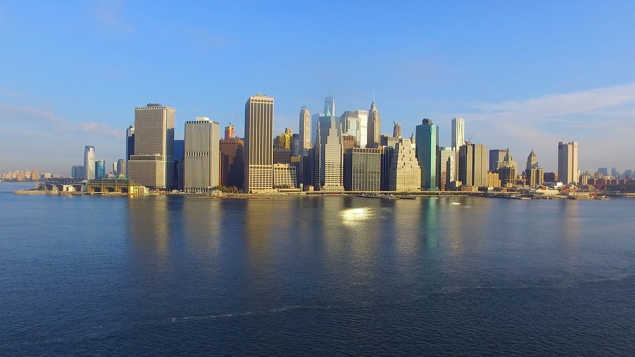 An aerial view of the new york city skyline over a body of water.