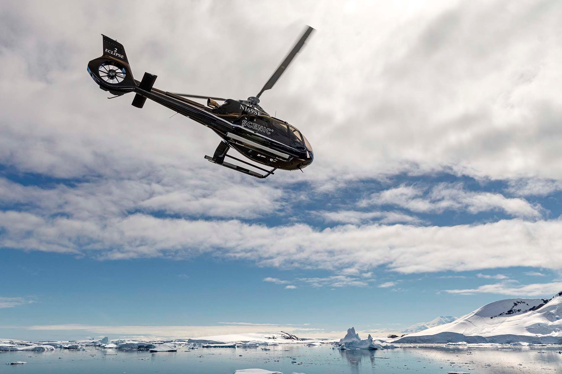 A helicopter is flying over antarctica. 