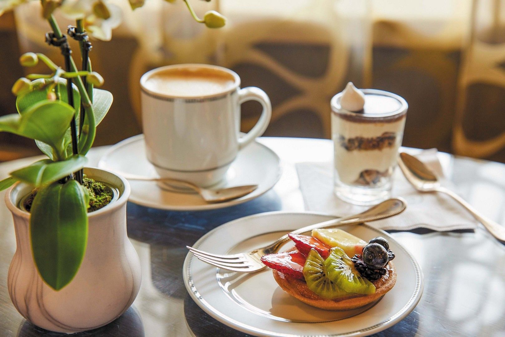 A table topped with plates of food and a cup of coffee at coffee connection on seven seas voyager