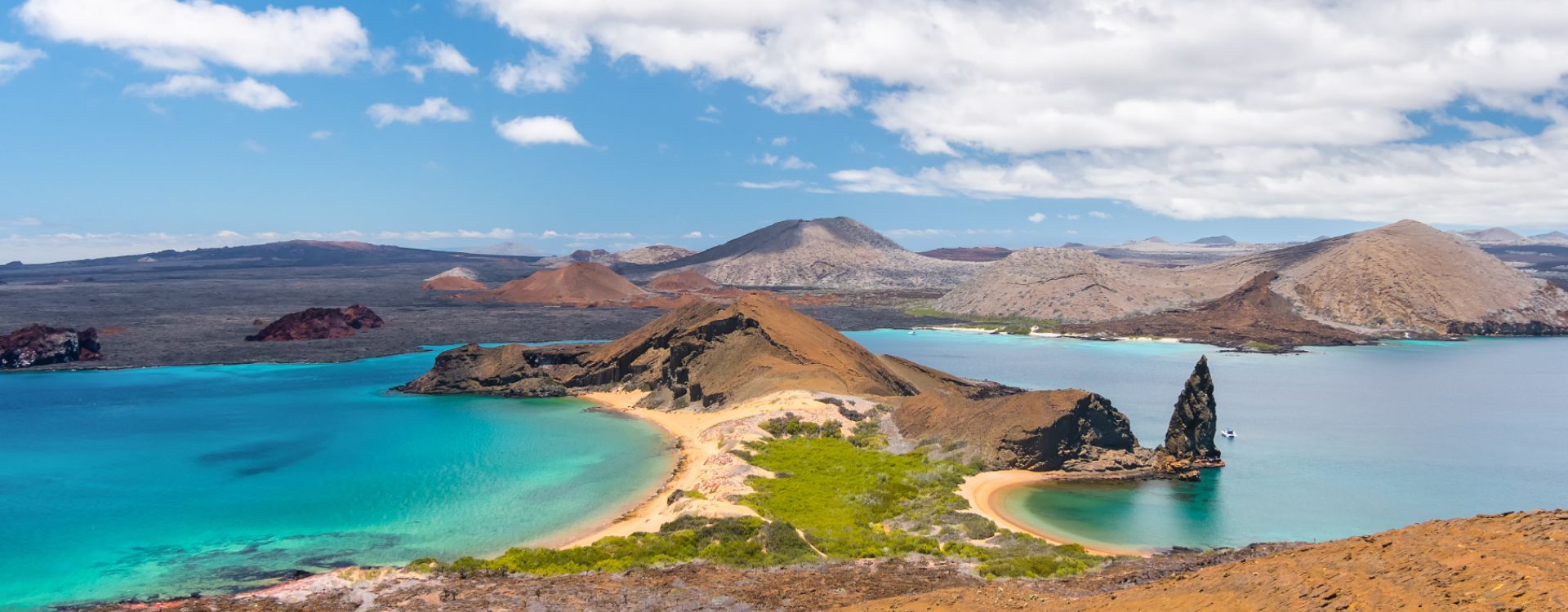 a small island in the middle of a large body of water surrounded by mountains  in the Galapagos