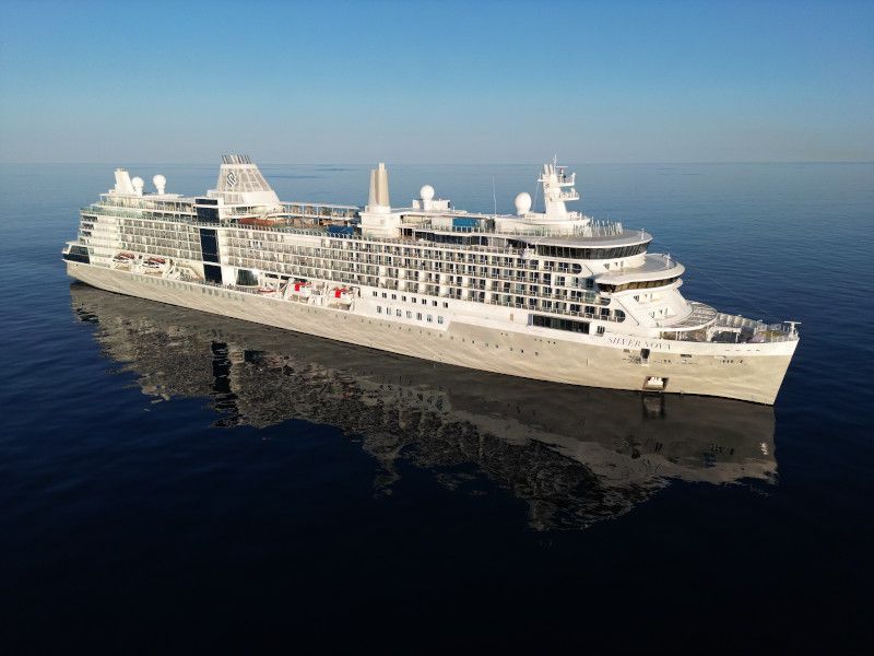 A large cruise ship is floating on top of a body of water called  Silver Nova