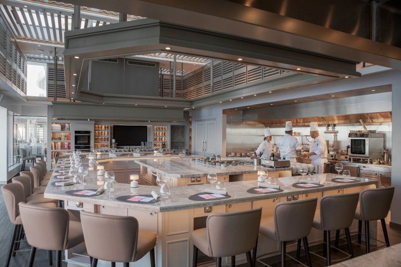 A large kitchen with a long table and chairs in it on Silver Nova cruise ship