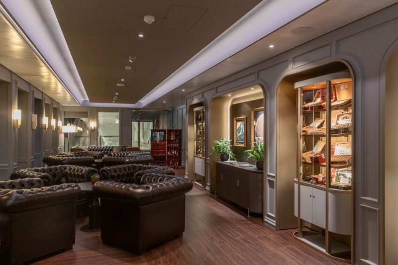 A long hallway with lots of chairs and a bookcase on Silver Nova cruise ship
