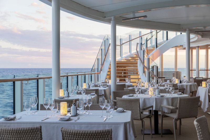 A restaurant on a cruise ship with tables and chairs overlooking the ocean on Silver Nova cruise ship