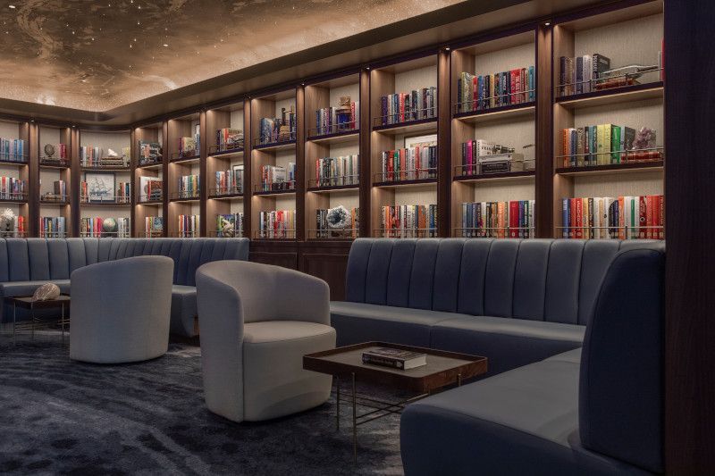 A living room filled with furniture and bookshelves on Silver Nova cruise ship