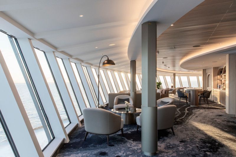A large room with a lot of windows and chairs on Silver Nova cruise ship