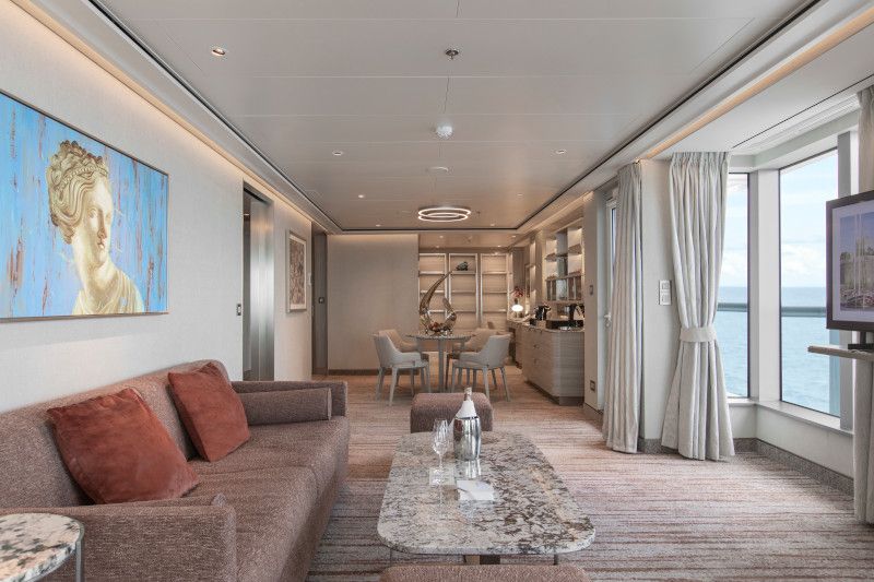 A living room with a couch , table , chairs and a television on Silver Nova cruise ship