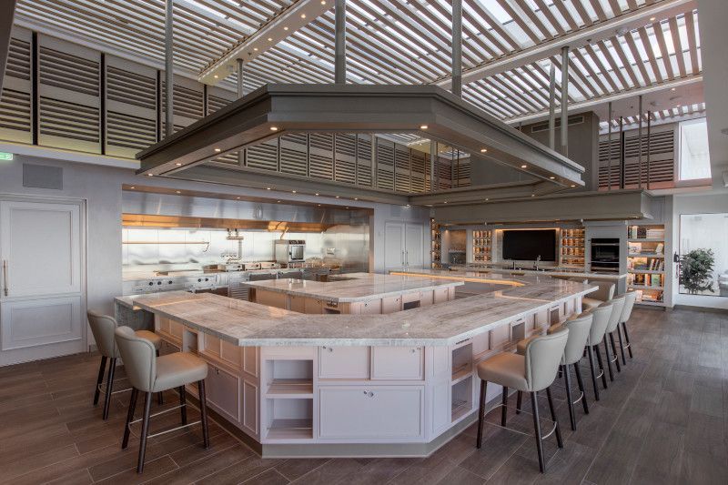 A large kitchen with a long counter and chairs on Silver Nova cruise ship